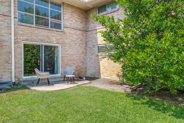 rear view of property with a yard and a patio area