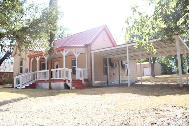 view of front of home featuring a storage shed, a porch, and a carport