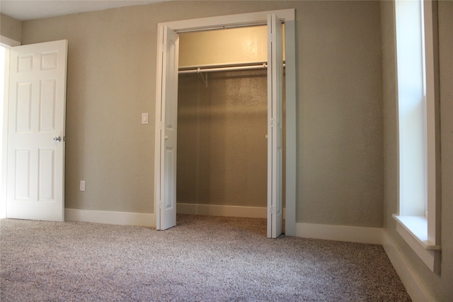 unfurnished bedroom with carpet and a closet