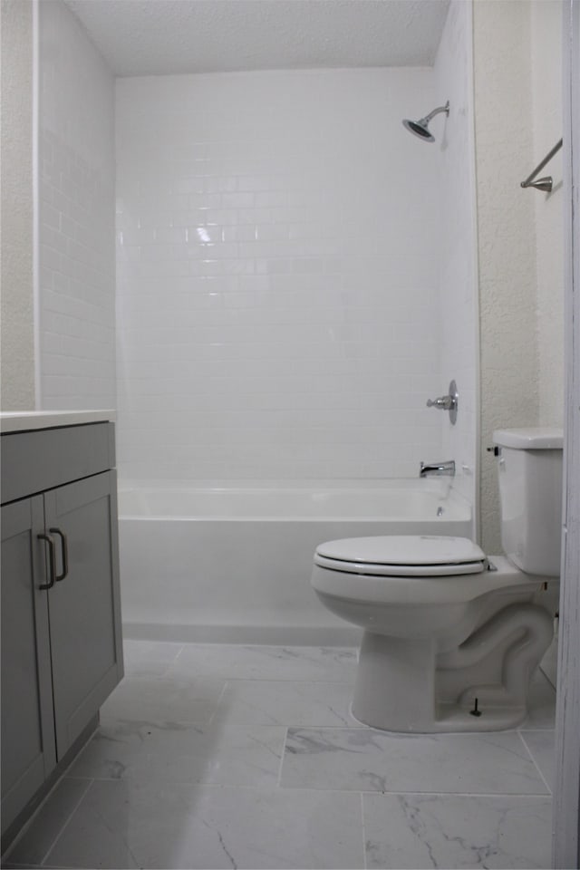 full bathroom featuring tiled shower / bath combo, vanity, toilet, and a textured ceiling