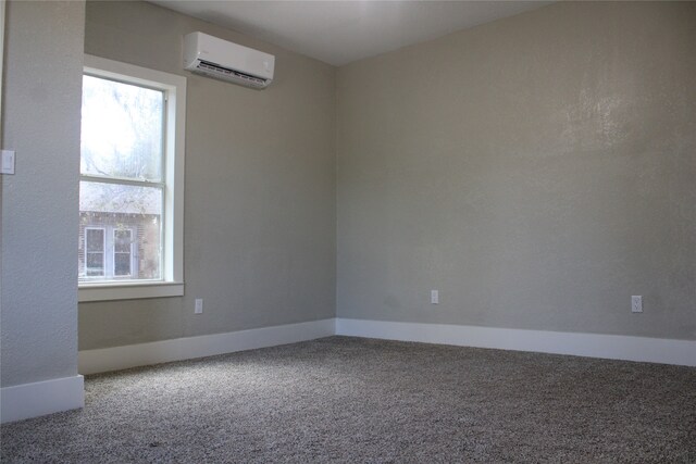 empty room with a wall mounted AC, plenty of natural light, and carpet floors