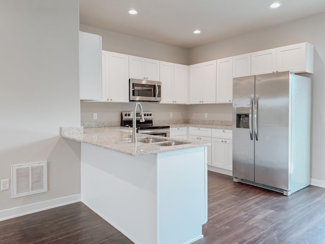 kitchen featuring white cabinetry, appliances with stainless steel finishes, dark hardwood / wood-style flooring, and kitchen peninsula