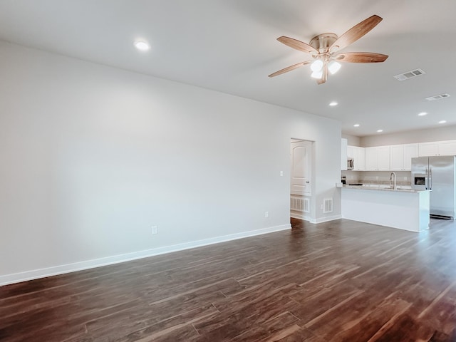 unfurnished living room featuring sink, dark hardwood / wood-style floors, and ceiling fan