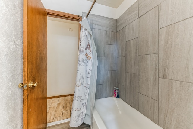 bathroom featuring hardwood / wood-style flooring and shower / bath combo with shower curtain