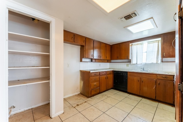 kitchen with visible vents, dishwasher, brown cabinetry, and light countertops