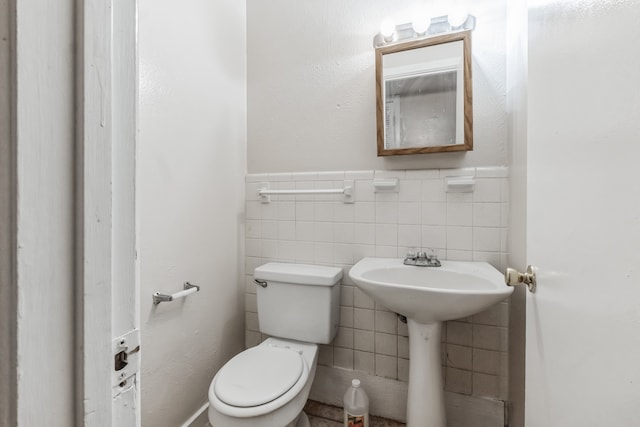 bathroom with decorative backsplash, tile walls, and toilet