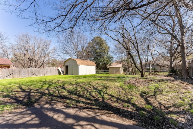 view of yard with an outbuilding, a storage unit, and fence