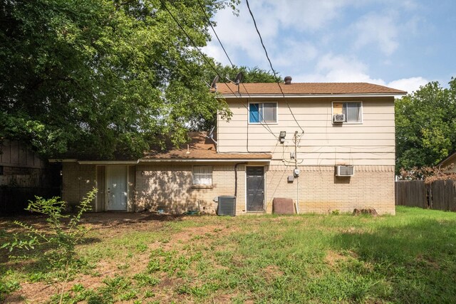 rear view of property with central AC and a lawn