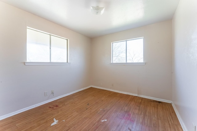 empty room featuring baseboards and wood finished floors