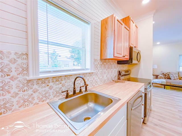 kitchen with crown molding, sink, dishwasher, range with electric cooktop, and light hardwood / wood-style flooring