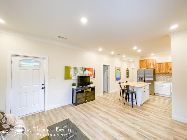 living room with light hardwood / wood-style floors and ornamental molding