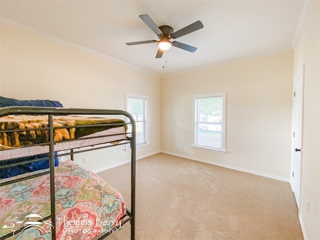 bedroom featuring ornamental molding, light carpet, and ceiling fan