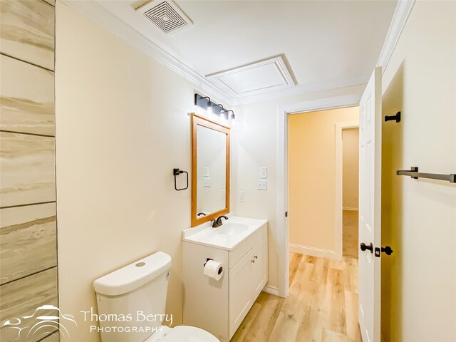 bathroom featuring hardwood / wood-style floors, vanity, ornamental molding, and toilet