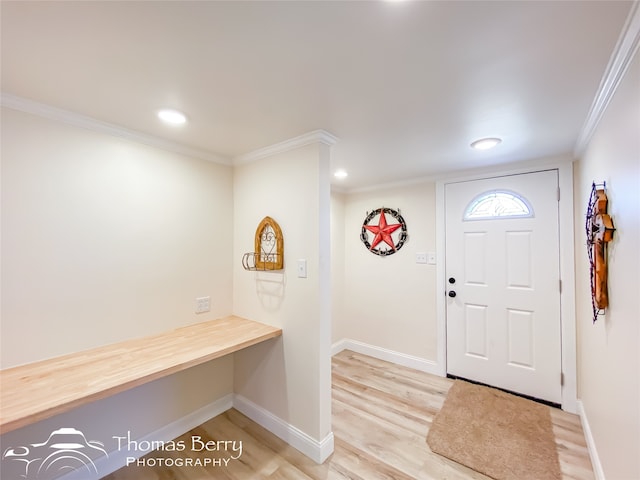 entryway featuring hardwood / wood-style flooring and crown molding