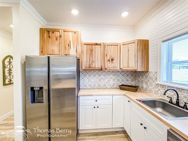 kitchen featuring light hardwood / wood-style floors, appliances with stainless steel finishes, white cabinetry, and tasteful backsplash