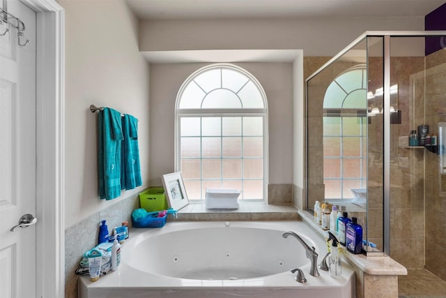 bathroom featuring independent shower and bath and a healthy amount of sunlight