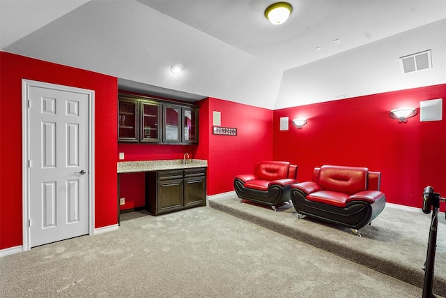 home theater room with light colored carpet, lofted ceiling, and indoor bar