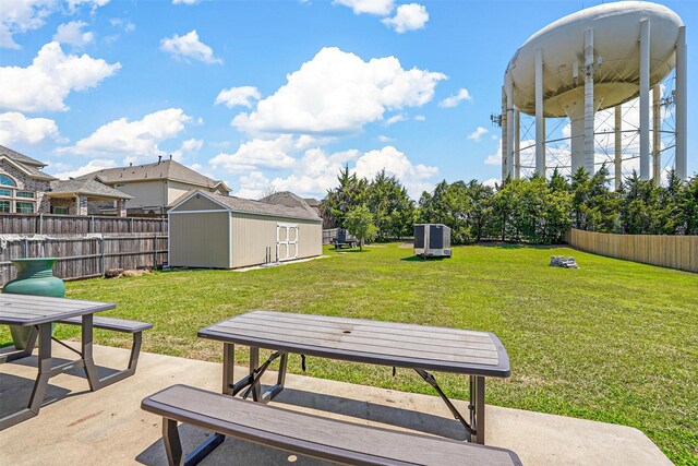 view of property's community featuring a storage shed, a yard, and a patio