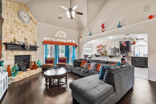 living room featuring ceiling fan, dark hardwood / wood-style floors, a fireplace, and high vaulted ceiling