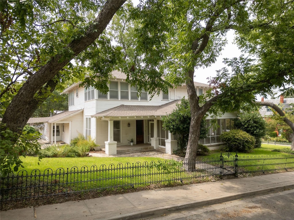 view of front of home featuring covered porch and a front lawn