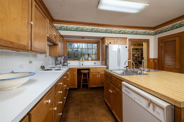 kitchen featuring backsplash, white appliances, sink, and dark tile patterned floors