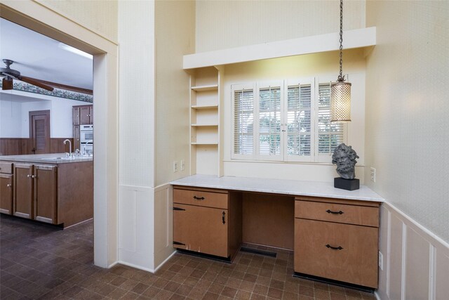 kitchen featuring ceiling fan, dark tile patterned floors, double oven, pendant lighting, and sink