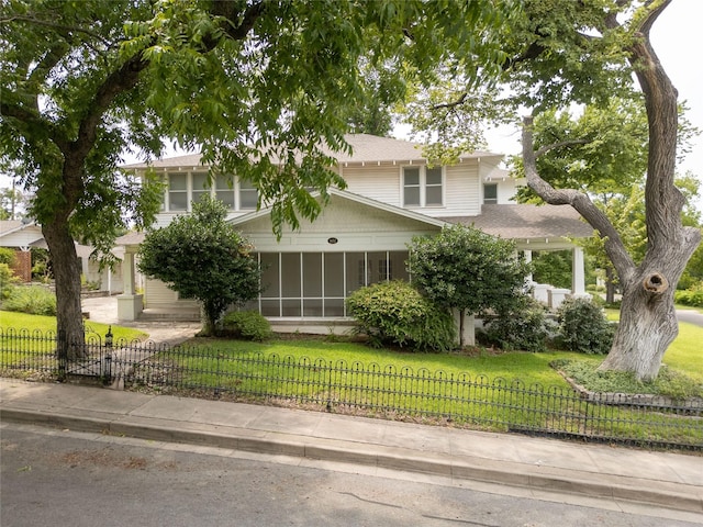 view of front of house with a sunroom and a front yard