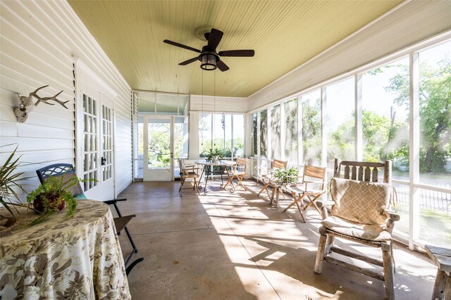 sunroom / solarium featuring french doors and ceiling fan