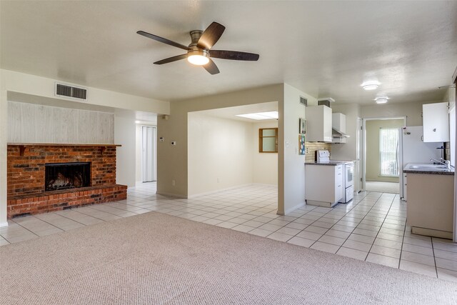 kitchen featuring white cabinetry, light carpet, and ceiling fan