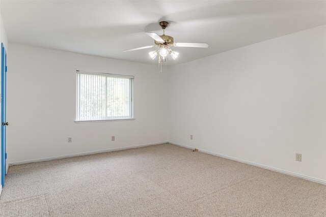 unfurnished room with light colored carpet and ceiling fan