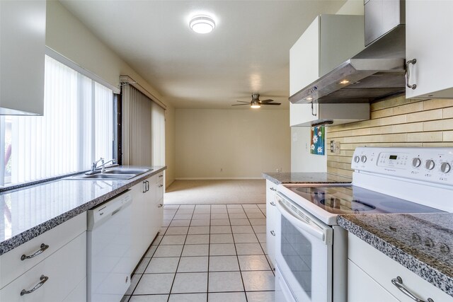 kitchen featuring light tile patterned flooring, white cabinetry, white appliances, wall chimney range hood, and sink