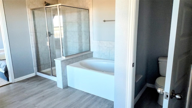 bathroom featuring hardwood / wood-style flooring, toilet, and separate shower and tub