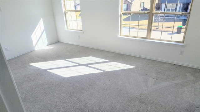 empty room with a wealth of natural light and light colored carpet