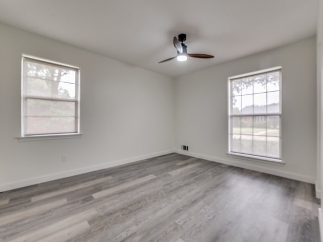 unfurnished room with wood-type flooring, ceiling fan, and plenty of natural light