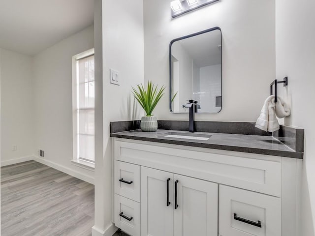 bathroom featuring wood finished floors, vanity, and baseboards