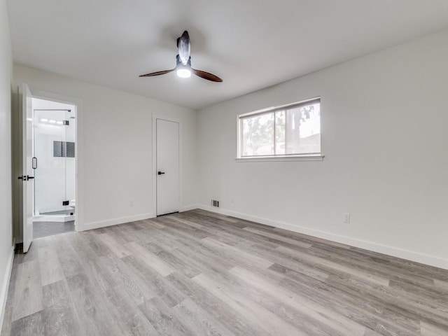 spare room featuring baseboards, ceiling fan, and light wood finished floors