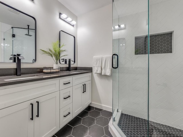 full bathroom with double vanity, a stall shower, tile patterned flooring, and a sink