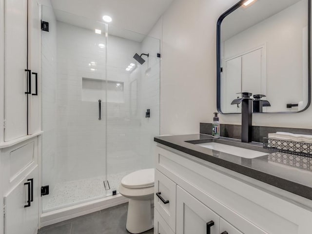 bathroom featuring a stall shower, tile patterned flooring, vanity, and toilet