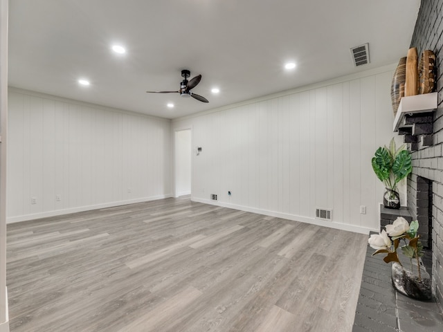 unfurnished living room with light hardwood / wood-style floors, a fireplace, and ceiling fan