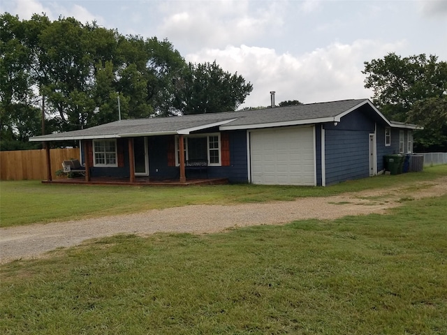 ranch-style house featuring a garage, a front yard, central AC unit, and covered porch