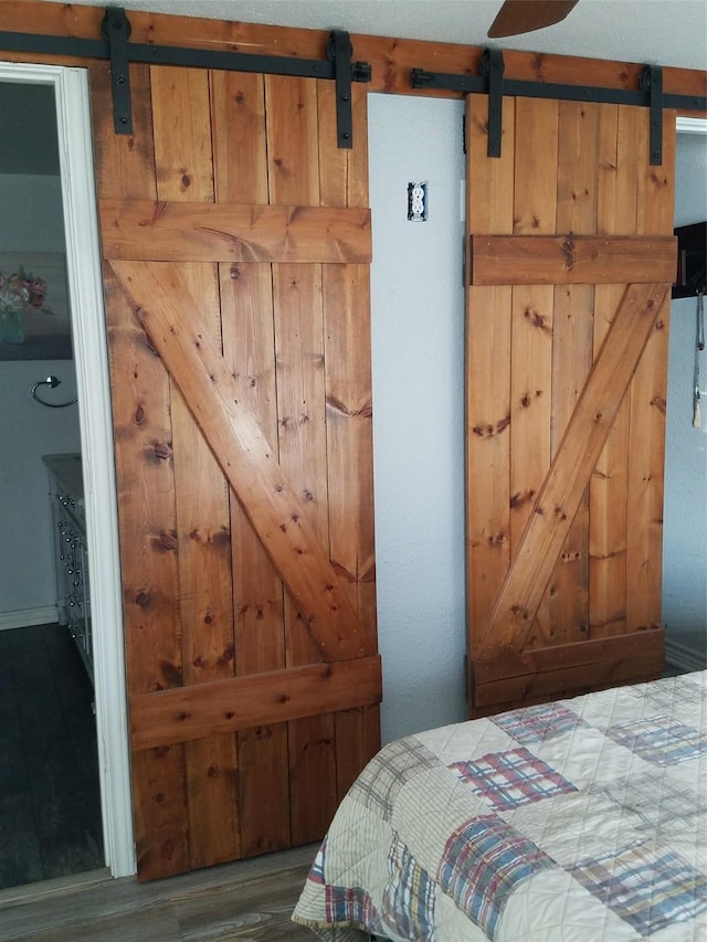 bedroom with hardwood / wood-style flooring and a barn door