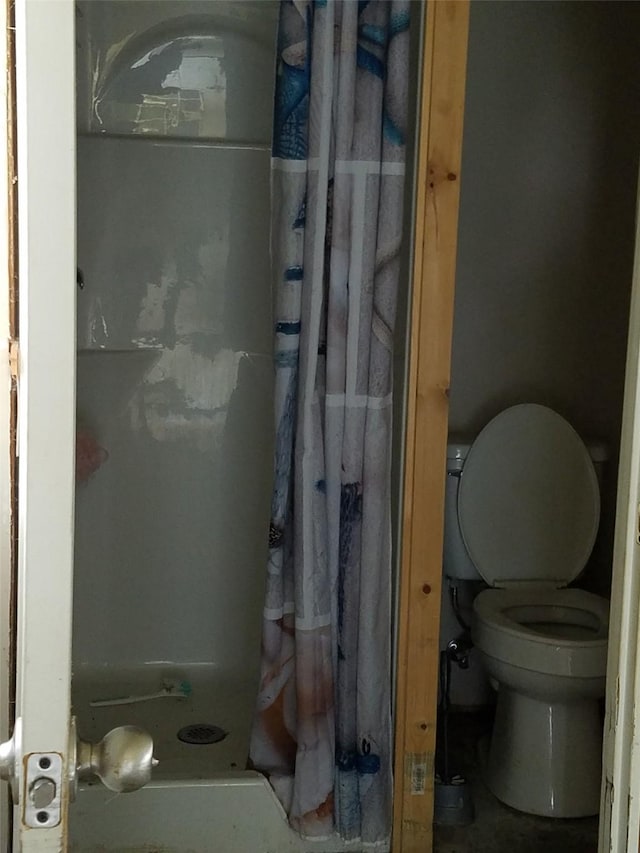 bathroom with curtained shower and toilet