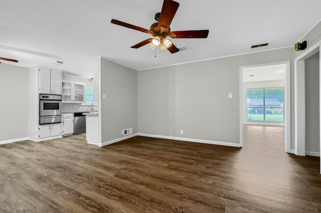 unfurnished living room with ornamental molding, dark wood-type flooring, and ceiling fan