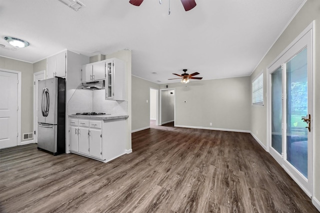 kitchen with white cabinetry, dark wood-type flooring, backsplash, and stainless steel refrigerator