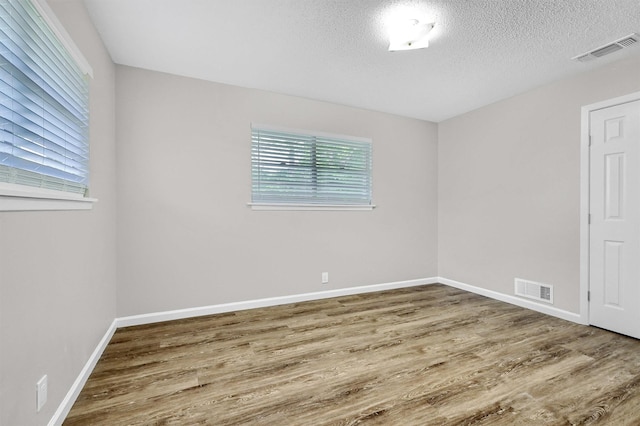 empty room featuring hardwood / wood-style flooring and a textured ceiling