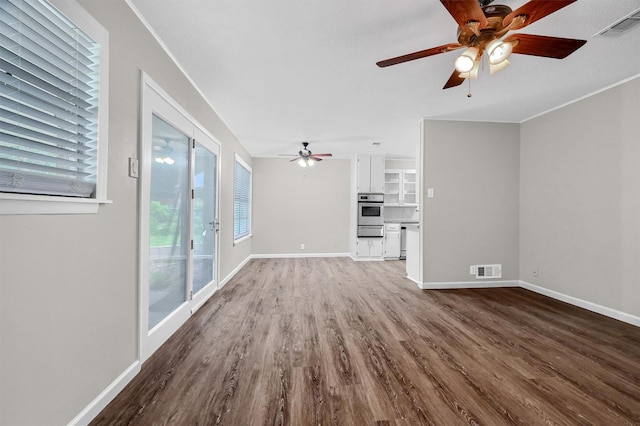 unfurnished living room featuring hardwood / wood-style flooring, ceiling fan, and crown molding