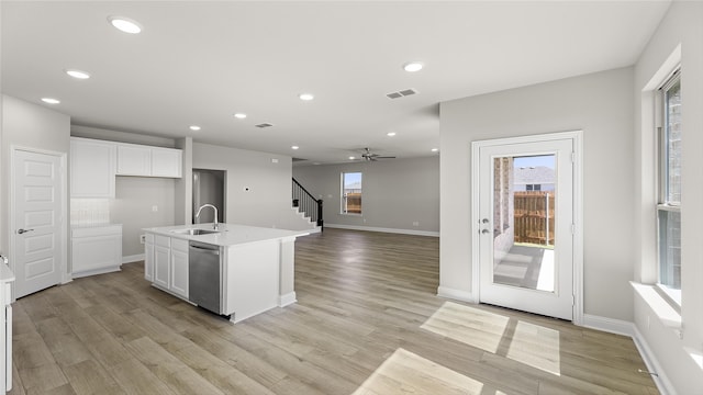 kitchen with dishwasher, a sink, white cabinetry, and recessed lighting