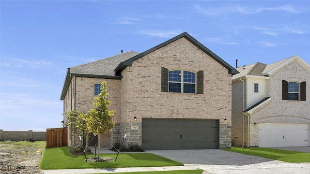 french country inspired facade featuring roof with shingles, driveway, an attached garage, brick siding, and fence