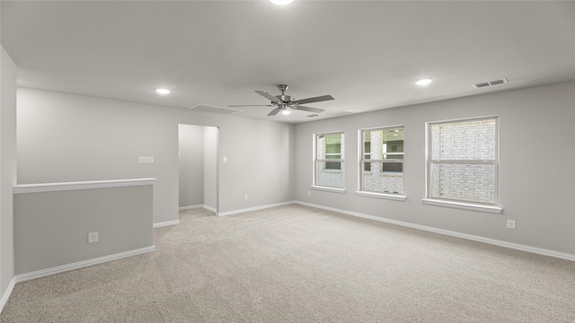 empty room featuring light colored carpet, baseboards, visible vents, and recessed lighting
