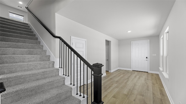 foyer featuring light wood-type flooring, baseboards, recessed lighting, stairway, and visible vents